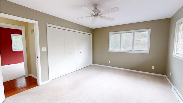 unfurnished bedroom featuring light carpet, ceiling fan, and a closet