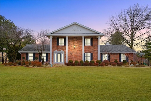 neoclassical home featuring a yard