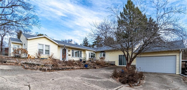 single story home with concrete driveway and a chimney