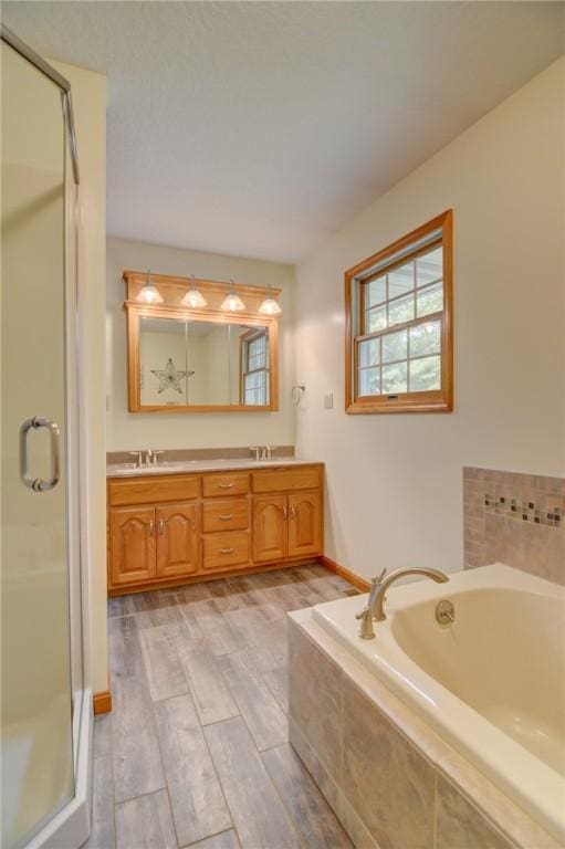 9234 E Cabin Rd, Oakley, IL 62501 - full bathroom with wood finished floors, double vanity, a stall shower, a sink, and a garden tub