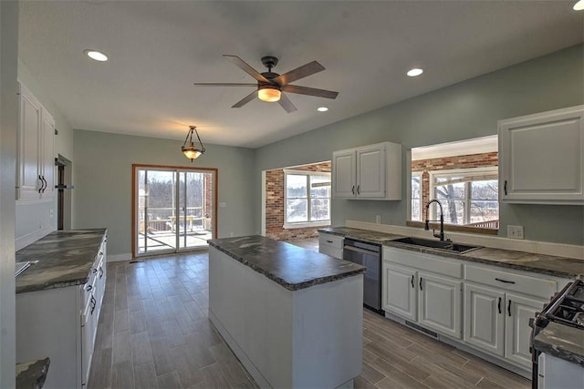 kitchen featuring gas stove, sink, stainless steel dishwasher, and white cabinets