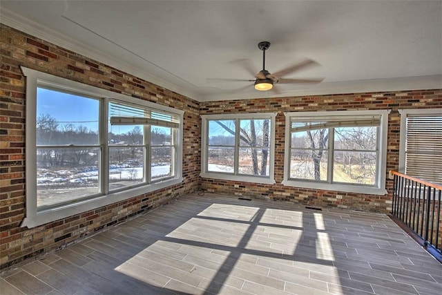 unfurnished sunroom featuring ceiling fan