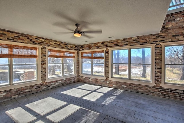 unfurnished sunroom with ceiling fan