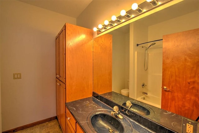 full bathroom featuring washtub / shower combination, vanity, and toilet