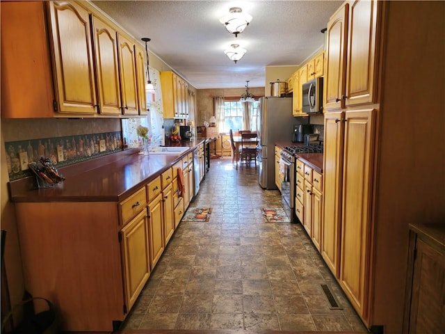 1622 S Cross St, Robinson, IL 62454 - kitchen featuring stainless steel appliances, dark countertops, pendant lighting, a sink, and a textured ceiling