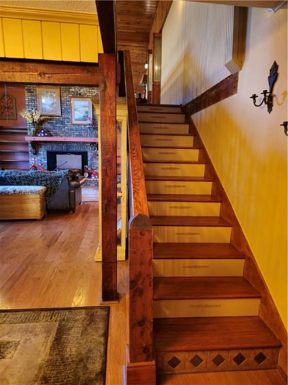 1622 S Cross St, Robinson, IL 62454 - staircase featuring wood finished floors and a fireplace