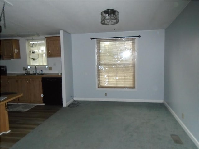 kitchen featuring black dishwasher, brown cabinets, dark carpet, and baseboards