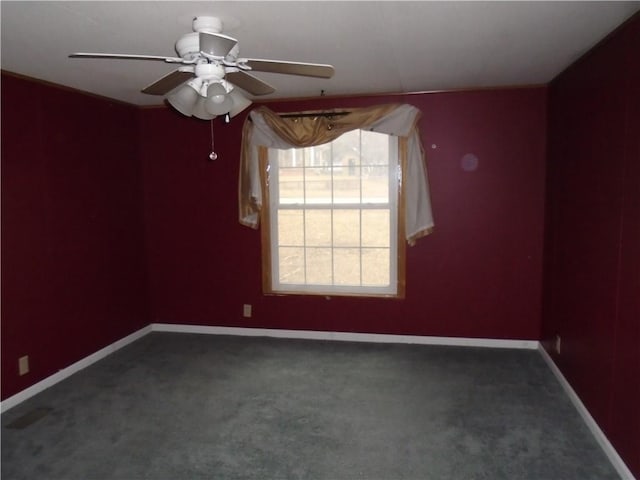 carpeted empty room featuring ceiling fan and baseboards