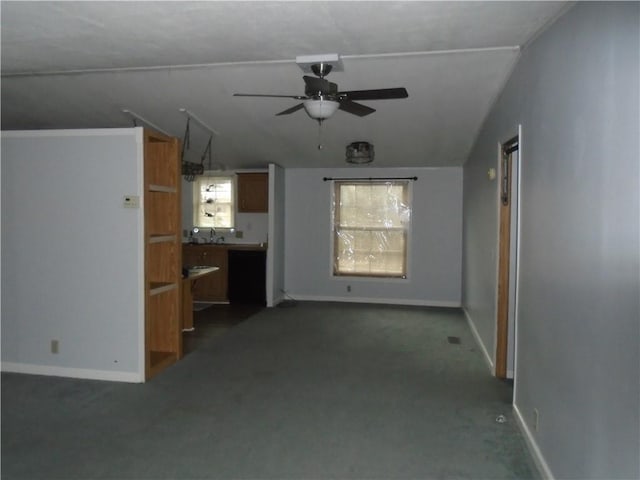 unfurnished living room featuring a sink, baseboards, and a ceiling fan