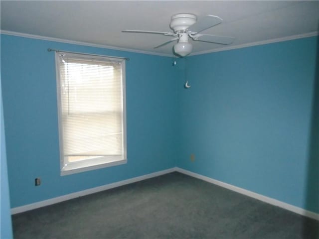 empty room with ornamental molding, dark carpet, plenty of natural light, and baseboards