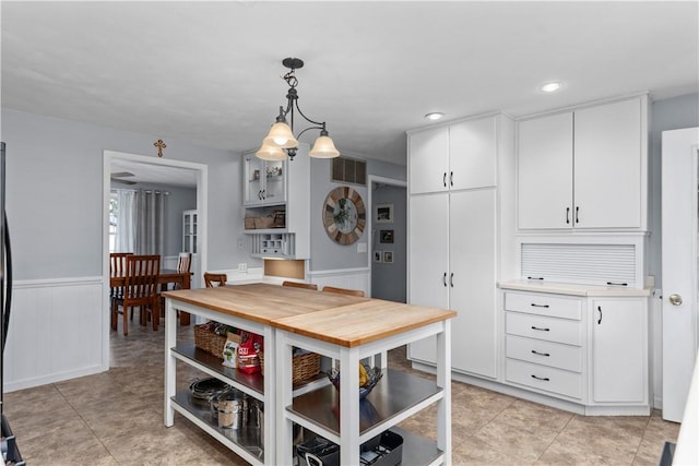 1022 Penguin St, Effingham, IL 62401 - kitchen featuring a wainscoted wall, decorative light fixtures, white cabinetry, light tile patterned floors, and light countertops