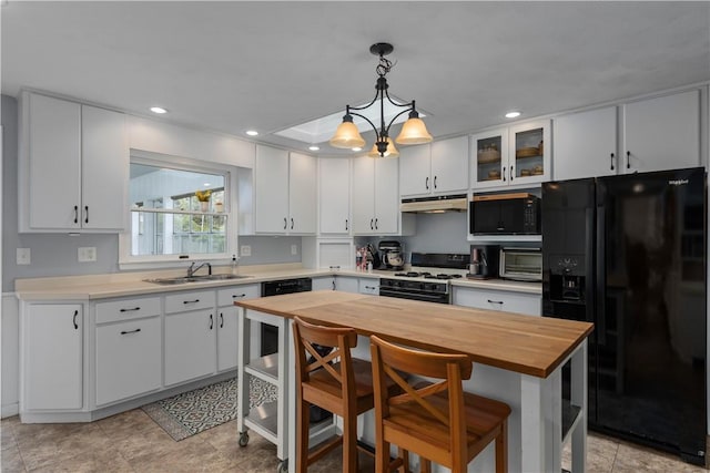 1022 Penguin St, Effingham, IL 62401 - kitchen with black appliances, under cabinet range hood, a sink, wood counters, and white cabinets