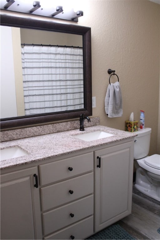 bathroom featuring hardwood / wood-style floors, vanity, and toilet