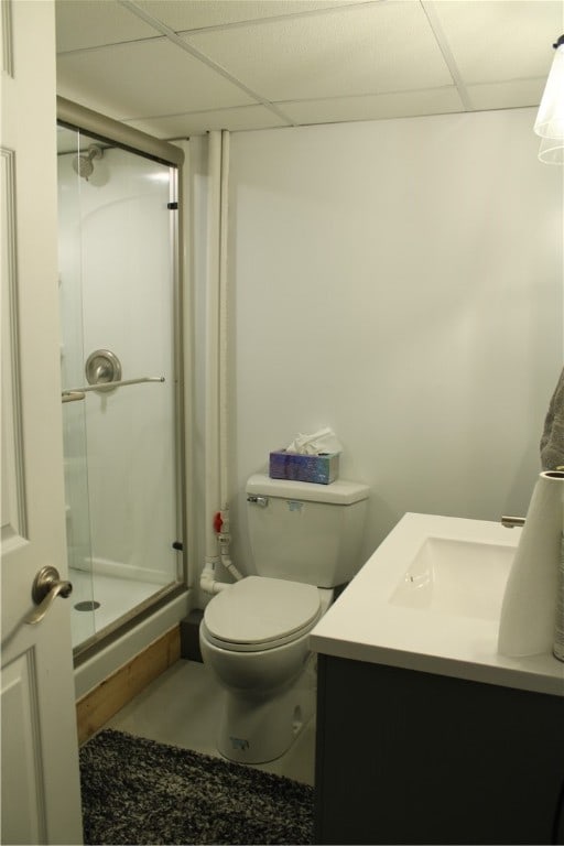 bathroom featuring a paneled ceiling, vanity, toilet, and walk in shower