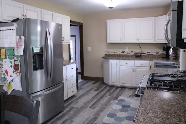 kitchen featuring white cabinets, appliances with stainless steel finishes, and hardwood / wood-style flooring