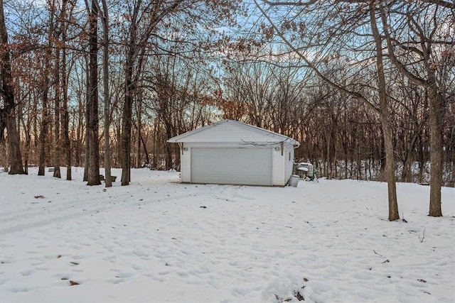 snowy yard with an outbuilding and a garage