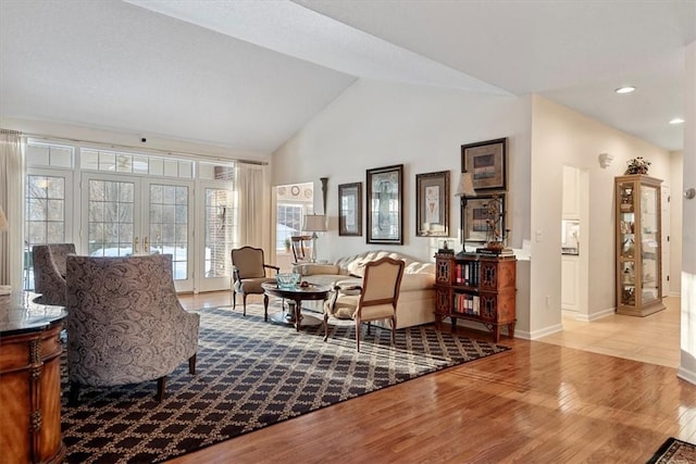 sitting room with light wood-type flooring, lofted ceiling, and french doors