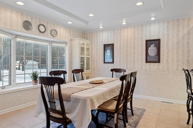 dining area with a raised ceiling and light tile patterned floors