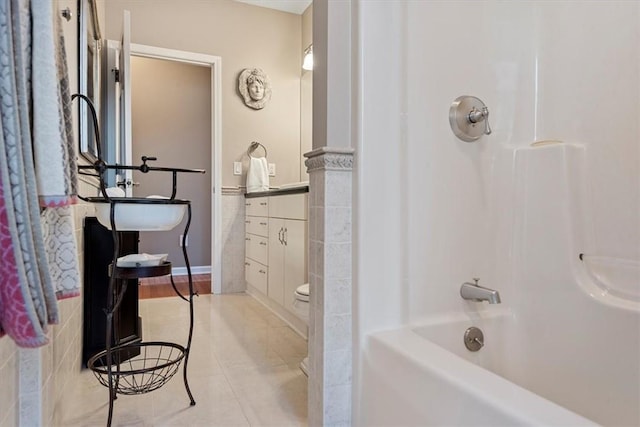 bathroom featuring bathtub / shower combination and toilet