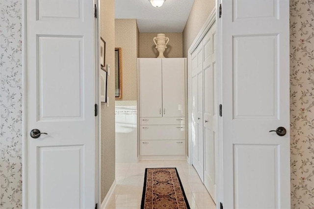 hallway featuring a textured ceiling and light tile patterned floors