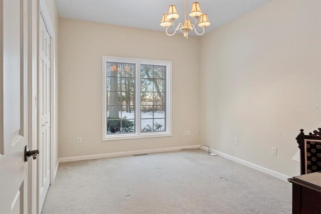 carpeted spare room with a notable chandelier