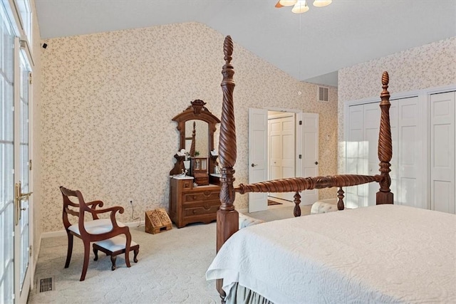 bedroom with lofted ceiling, carpet floors, ceiling fan, multiple closets, and french doors