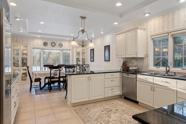 kitchen featuring hanging light fixtures, dishwasher, a tray ceiling, and sink