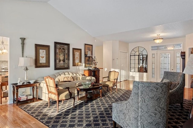 living room featuring vaulted ceiling and wood-type flooring