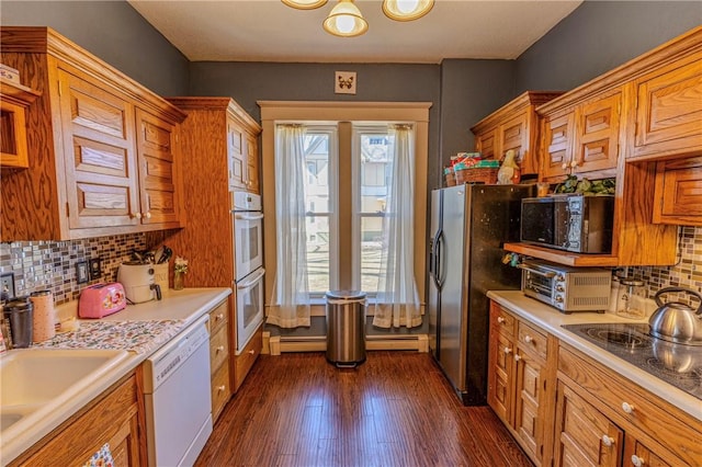 kitchen with light countertops, white dishwasher, black microwave, and dark wood-type flooring