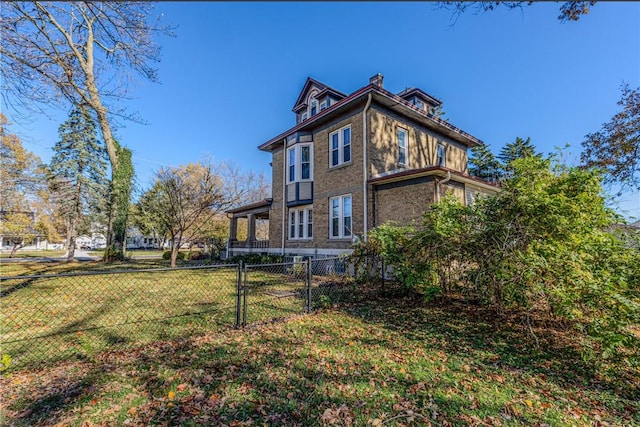 back of property featuring a lawn, brick siding, and fence