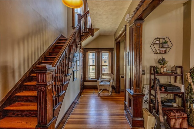 foyer featuring hardwood / wood-style floors, stairs, and baseboards