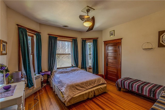 bedroom featuring visible vents, hardwood / wood-style floors, and a ceiling fan