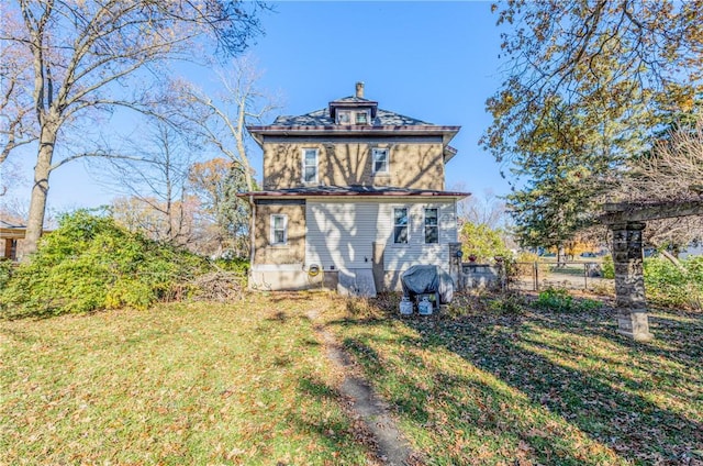 back of property with a yard and fence