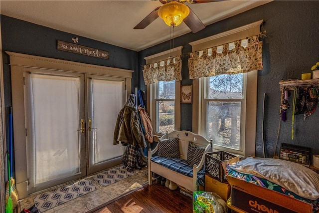 interior space with a ceiling fan, wood finished floors, and french doors