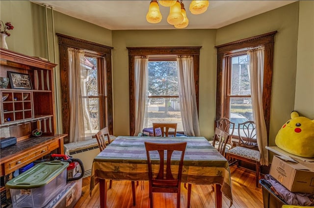 dining space featuring a notable chandelier and wood-type flooring