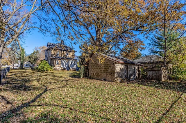 view of yard featuring an outbuilding and fence