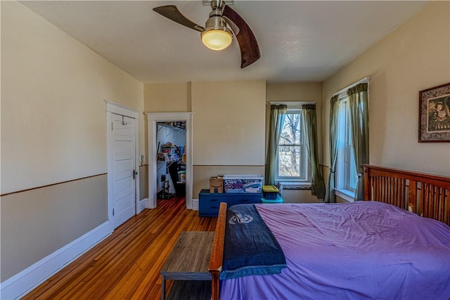 bedroom with ceiling fan, baseboards, and wood finished floors