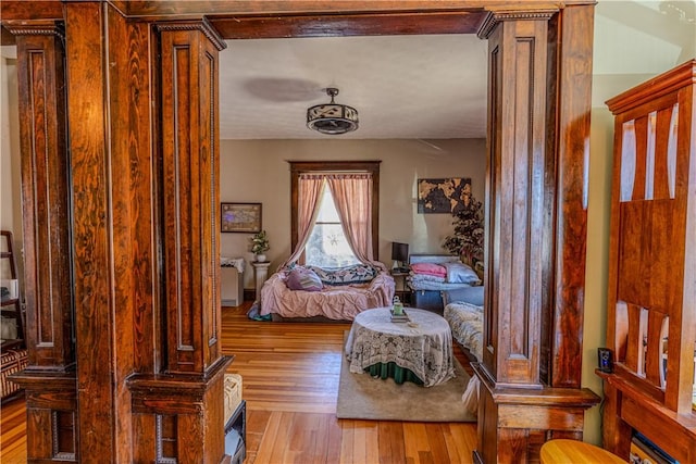 interior space with decorative columns and hardwood / wood-style floors