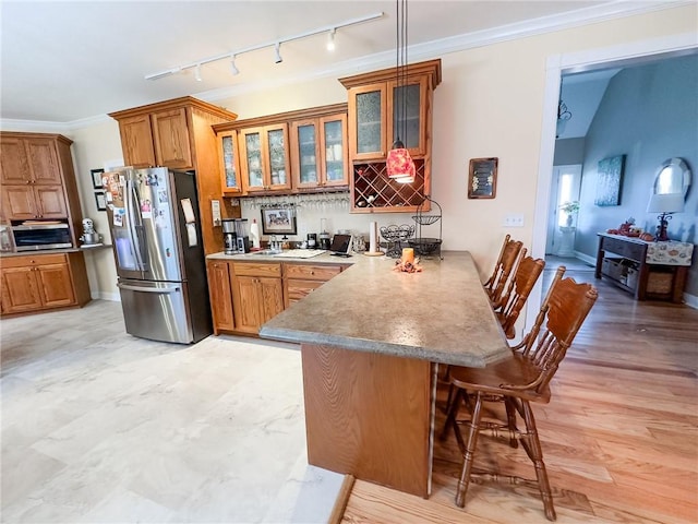 1165 Crooked Ln, Dennison, IL 62423 - kitchen with stainless steel refrigerator with ice dispenser, a peninsula, a kitchen breakfast bar, and brown cabinetry