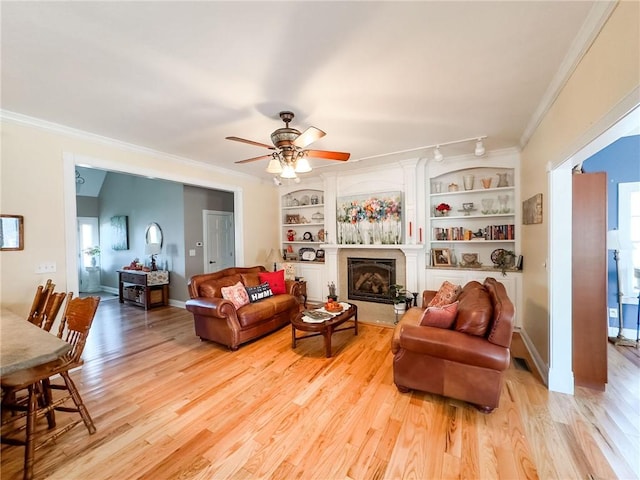 1165 Crooked Ln, Dennison, IL 62423 - living room with ornamental molding, a ceiling fan, a glass covered fireplace, and light wood-style floors