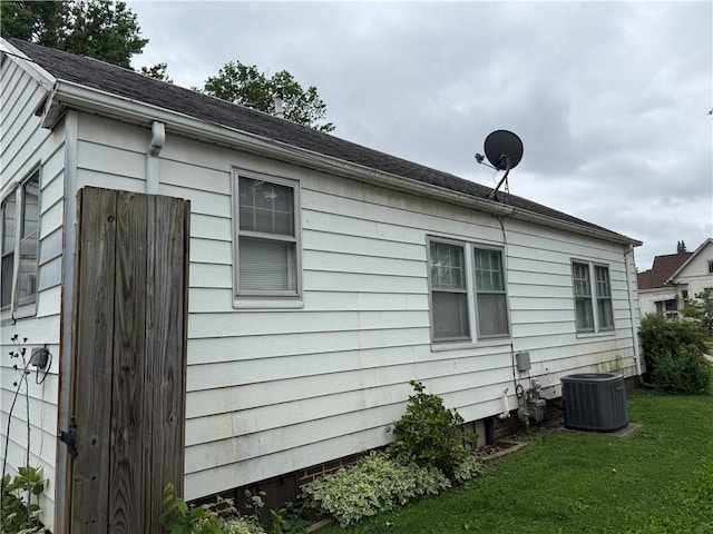 706 Douglas St, Paris, IL 61944 - view of home's exterior with central AC, a yard, and a shingled roof