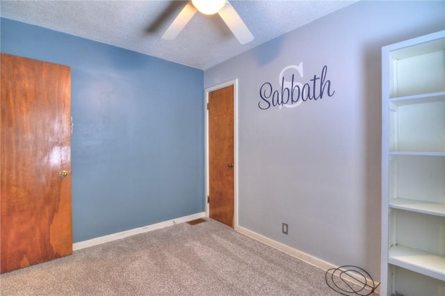 carpeted spare room with ceiling fan and a textured ceiling