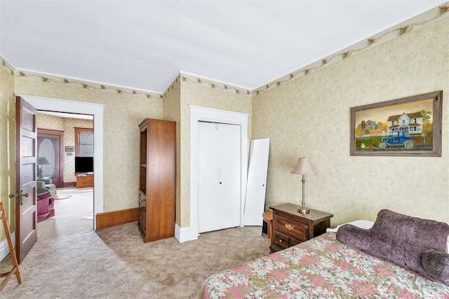 carpeted bedroom featuring wallpapered walls and a closet