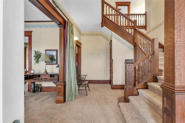 stairs featuring carpet, decorative columns, baseboards, and crown molding