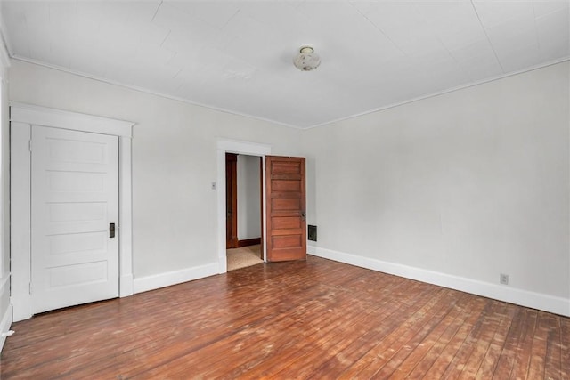 empty room featuring baseboards and hardwood / wood-style flooring