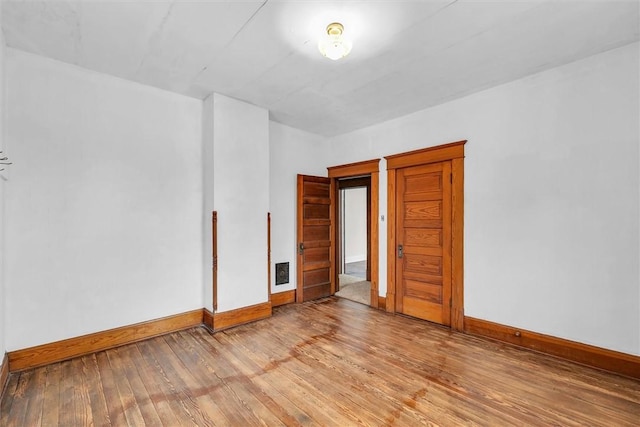 unfurnished room with visible vents, light wood-style flooring, and baseboards