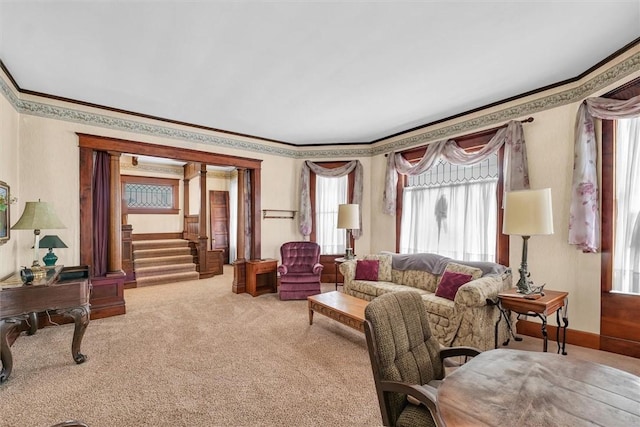 carpeted living room featuring crown molding and stairs