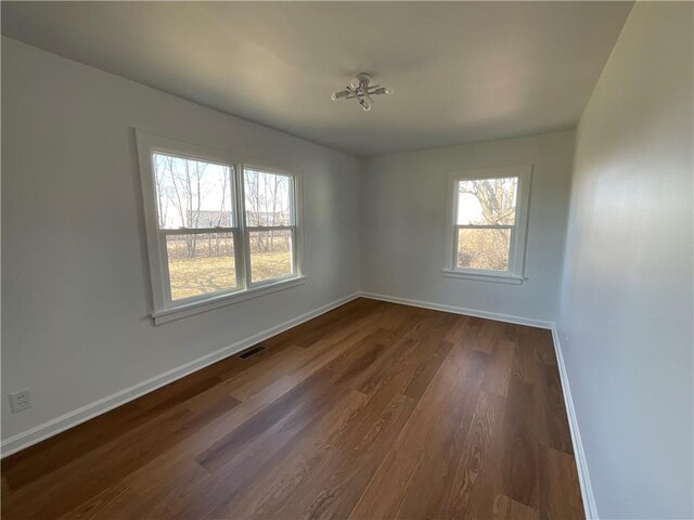108 W Virginia Ave, Effingham, IL 62401 - spare room with dark wood-style floors, visible vents, plenty of natural light, and baseboards