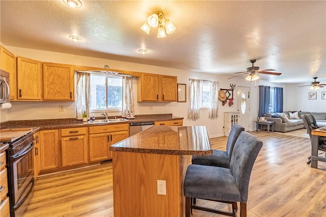 2430 Baker Ln, Decatur, IL 62526 - kitchen featuring appliances with stainless steel finishes, a breakfast bar area, open floor plan, a center island, and a ceiling fan