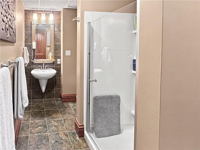 bathroom featuring a stall shower and tile walls